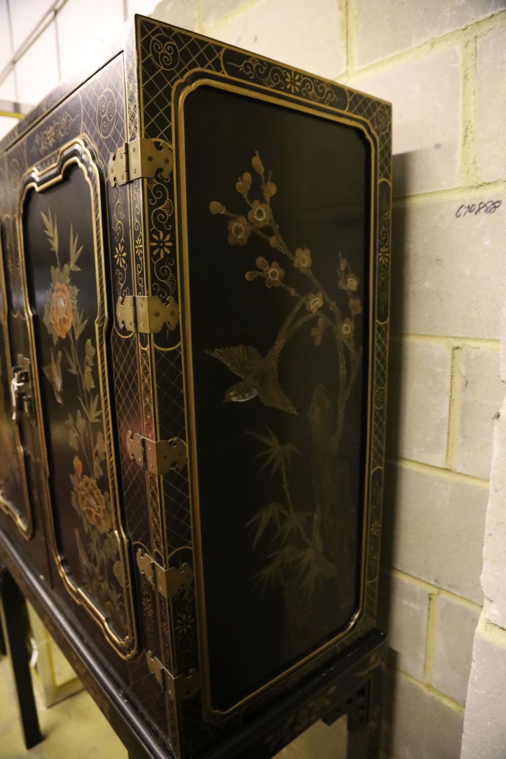 A Chinese black-lacquered and painted cabinet on stand, width 106cm, depth 46cm, height 173cm